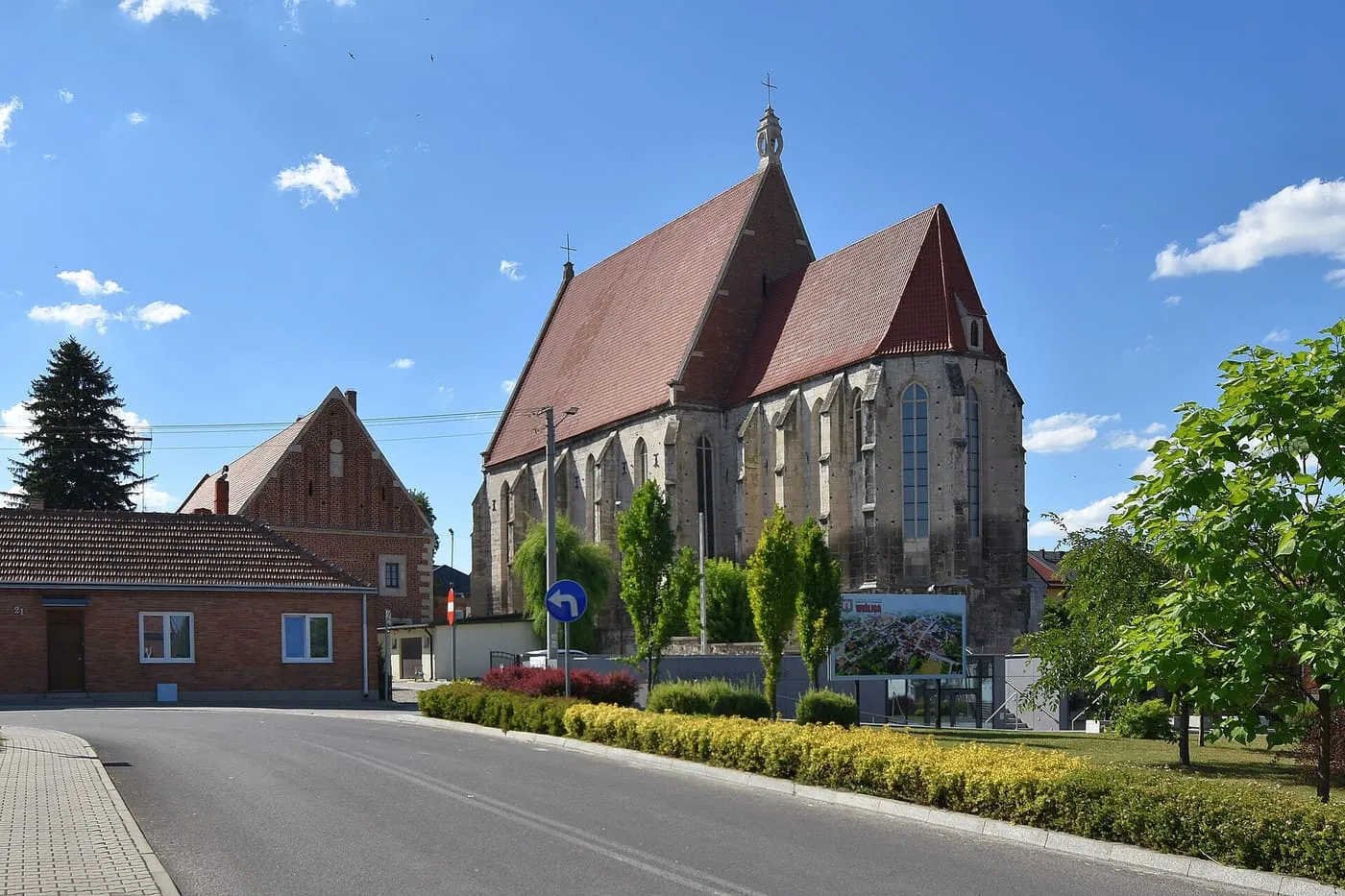 Gotycka bazylika kolegiacka w Wiślicy z wysokim, stromym dachem i wieżyczką zwieńczoną krzyżem