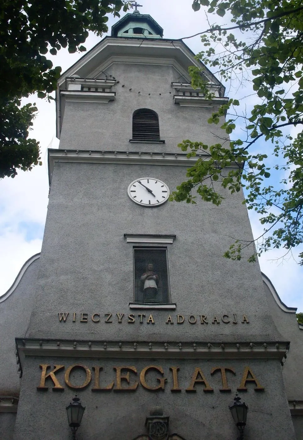 Wieża zegarowa bazyliki kolegiackiej w Gdyni z napisami KOLEGIATA i WIECZYSTA ADORACJA