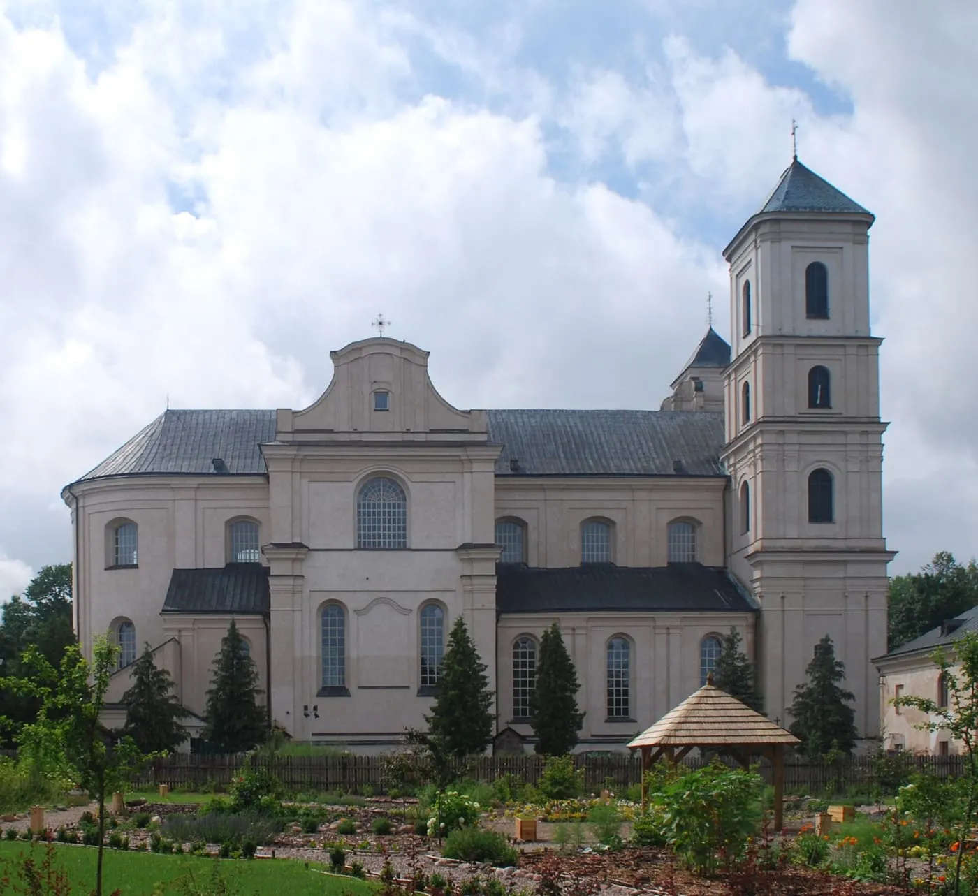 Barokowa bazylika w Różanymstoku z wieżą i przylegającym klasztorem, widziana od strony ogrodu