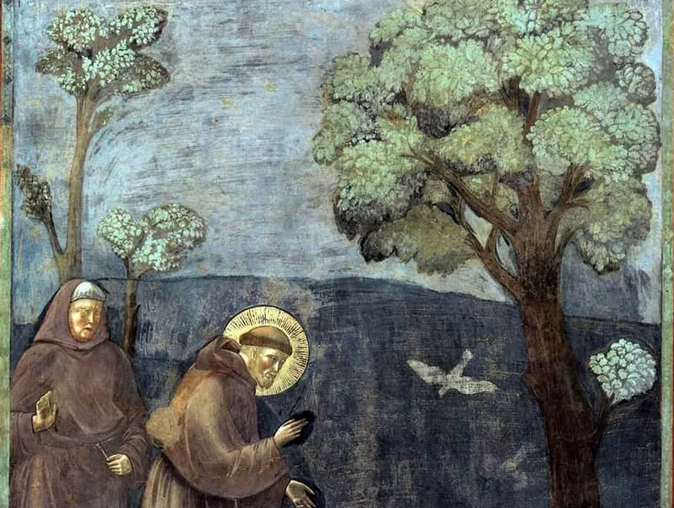 Fresk z asyskiej bazyliki: święty Franciszek z nimbem, w brązowym habicie, pochyla się nad ptakami przy podnóżu drzewa, obok stoi drugi brat w kapturze, w tle wzgórze i błękitne niebo