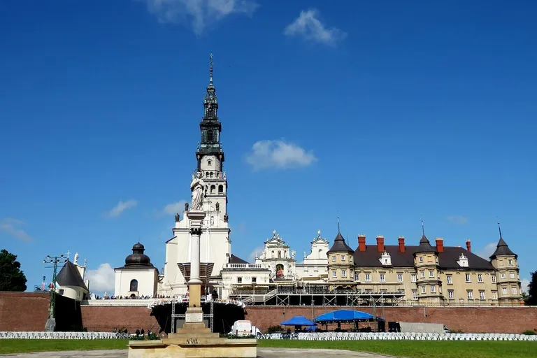 Klasztor jasnogórski z charakterystyczną, wysoką wieżą zwieńczoną figurą, otoczony murami obronnymi