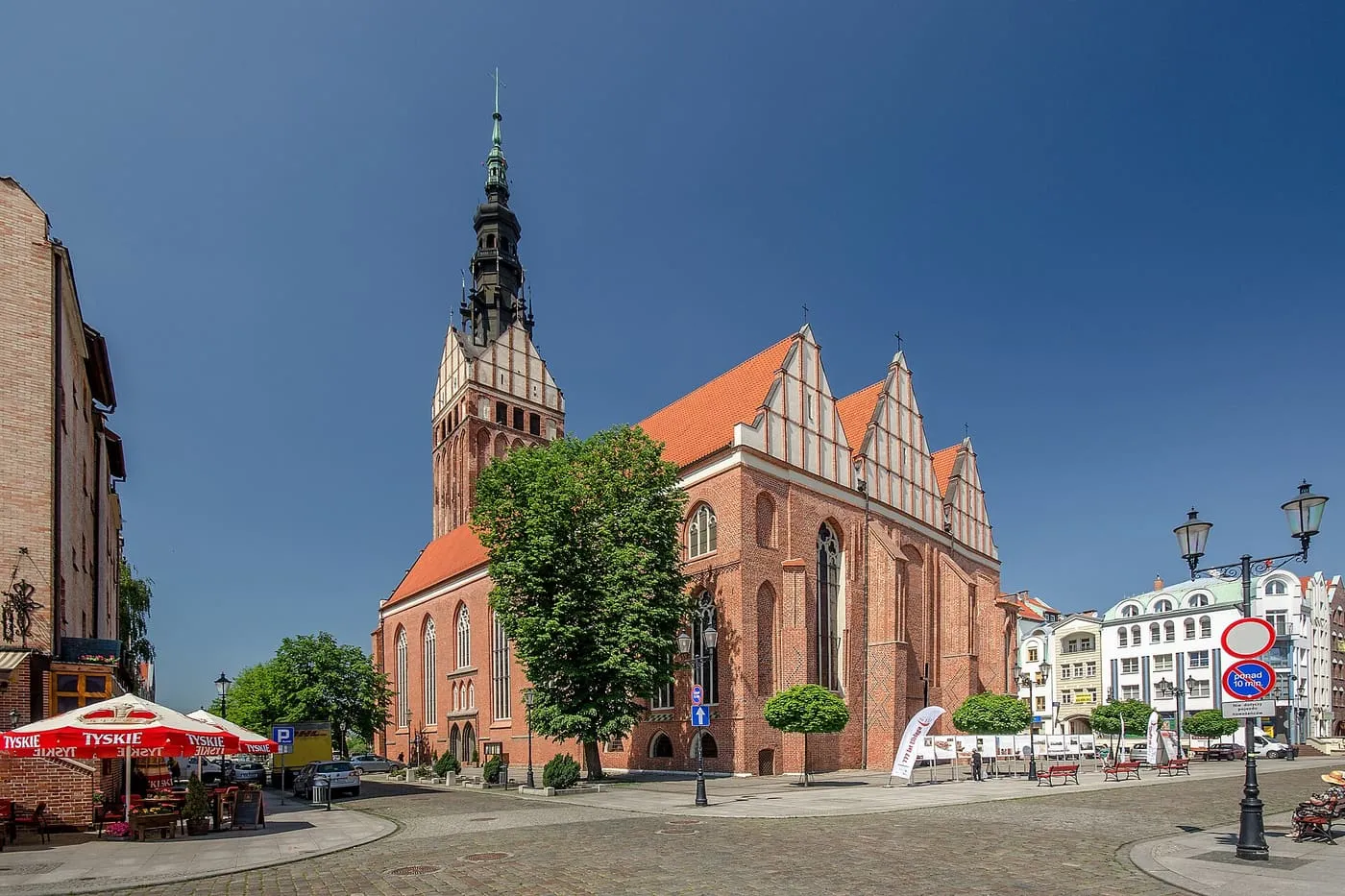 Gotycka katedra św. Mikołaja w Elblągu z wysoką ceglaną wieżą, widziana ze starówki
