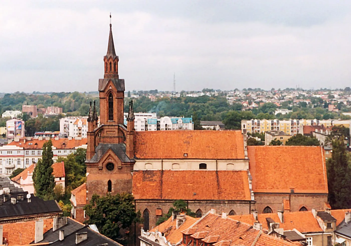 Ceglana wieża katedry św. Mikołaja w Kaliszu ponad dachami starego miasta