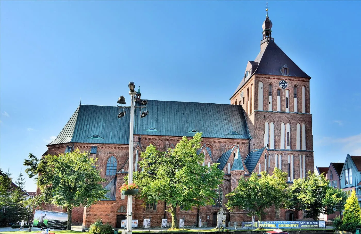 Gotycka katedra w Koszalinie z charakterystyczną wieżą zwieńczoną cebulastą latarnią, nad rzeką