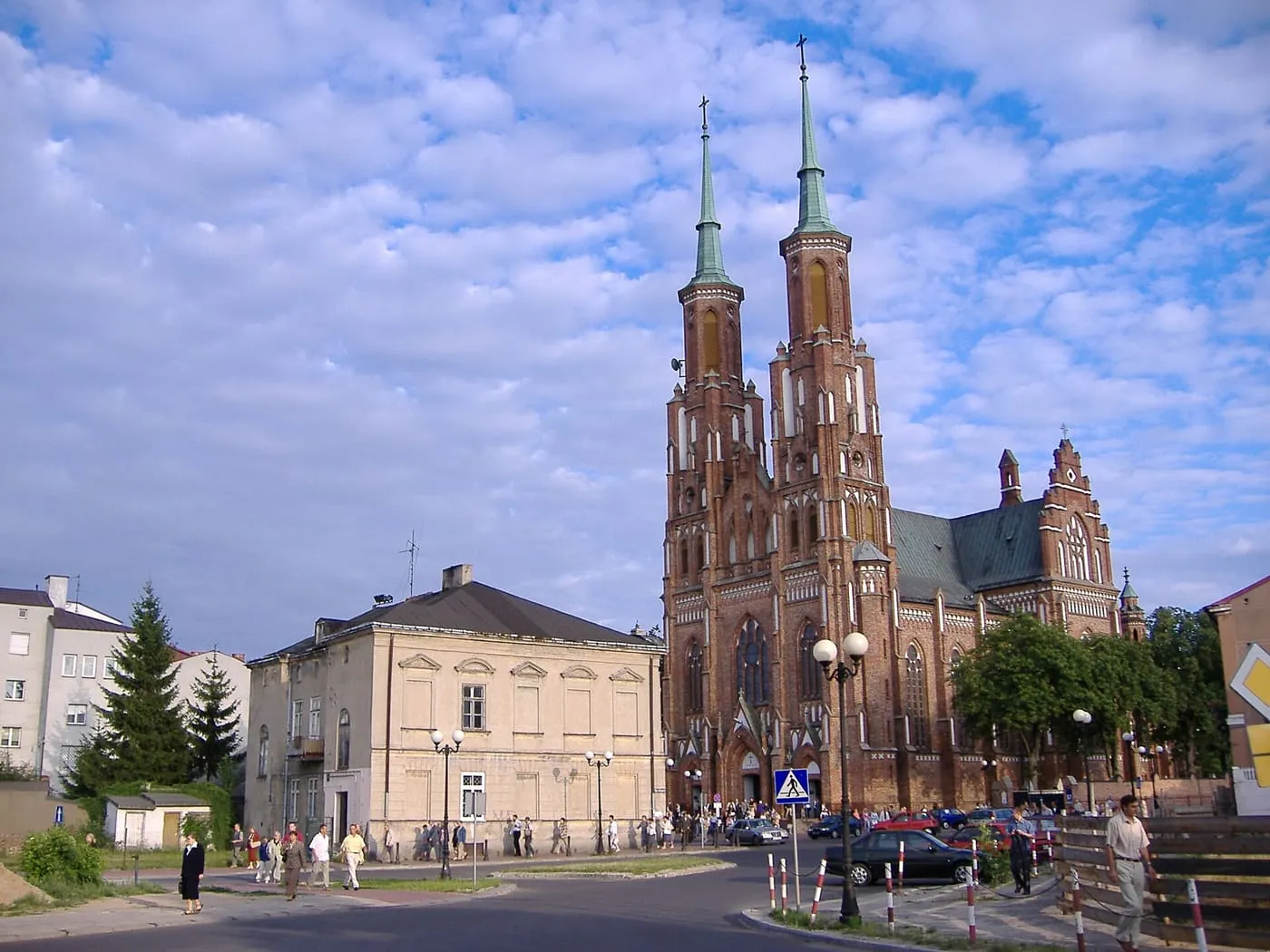 Neogotycka katedra w Siedlcach z dwiema ceglanymi wieżami, widziana z placu miejskiego