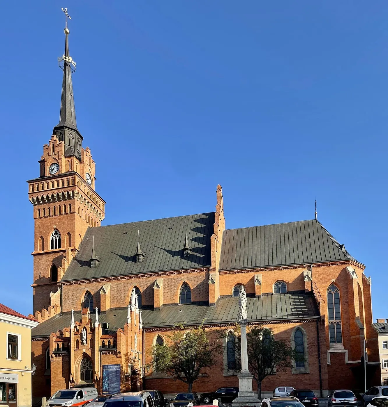 Ceglana katedra tarnowska z dwiema smukłymi wieżami, z lotu ptaka w złotym świetle zachodzącego słońca