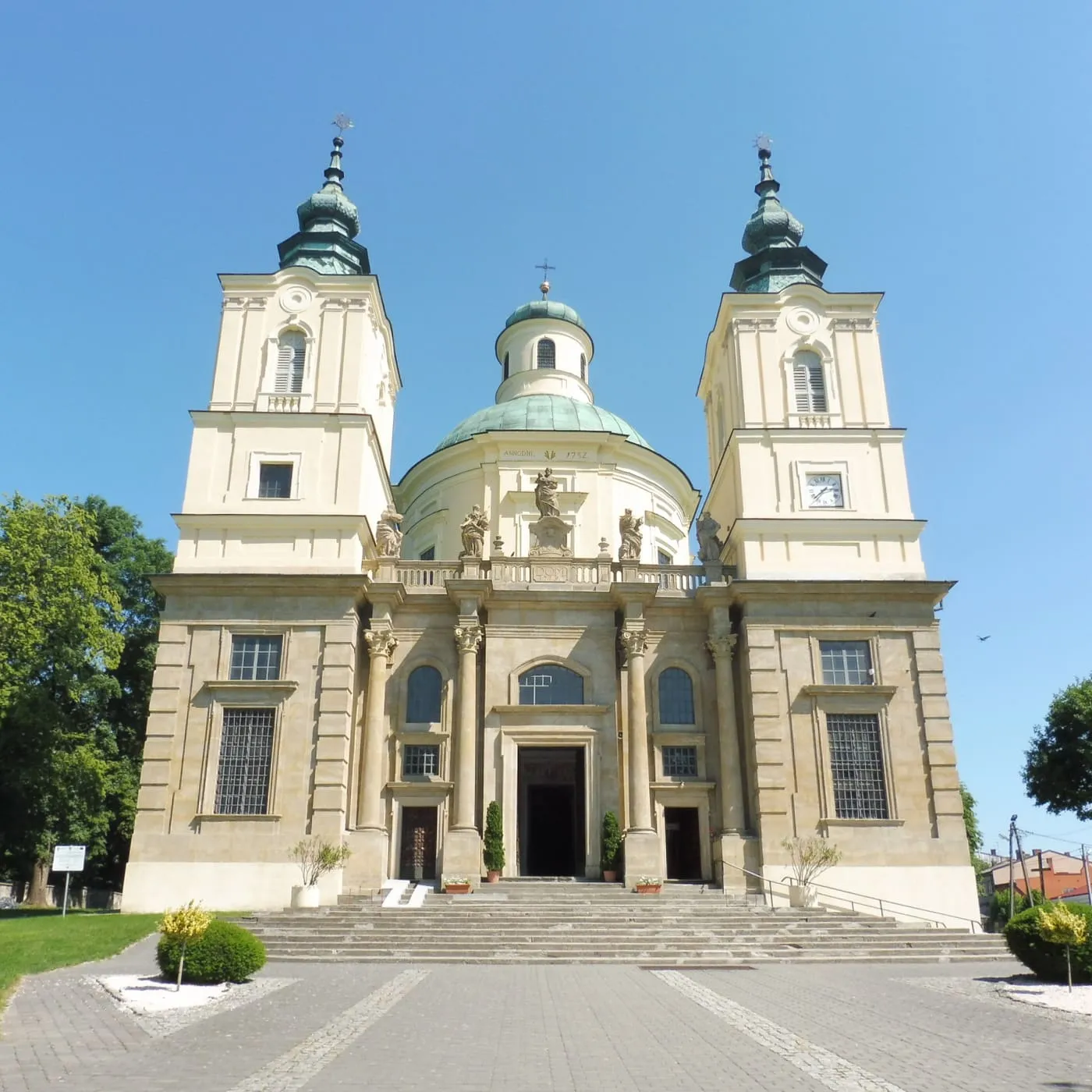 Kremowa, barokowa kolegiata św. Józefa w Klimontowie na planie elipsy, z kopułą i dwiema wieżami zwieńczonymi cebulastymi hełmami