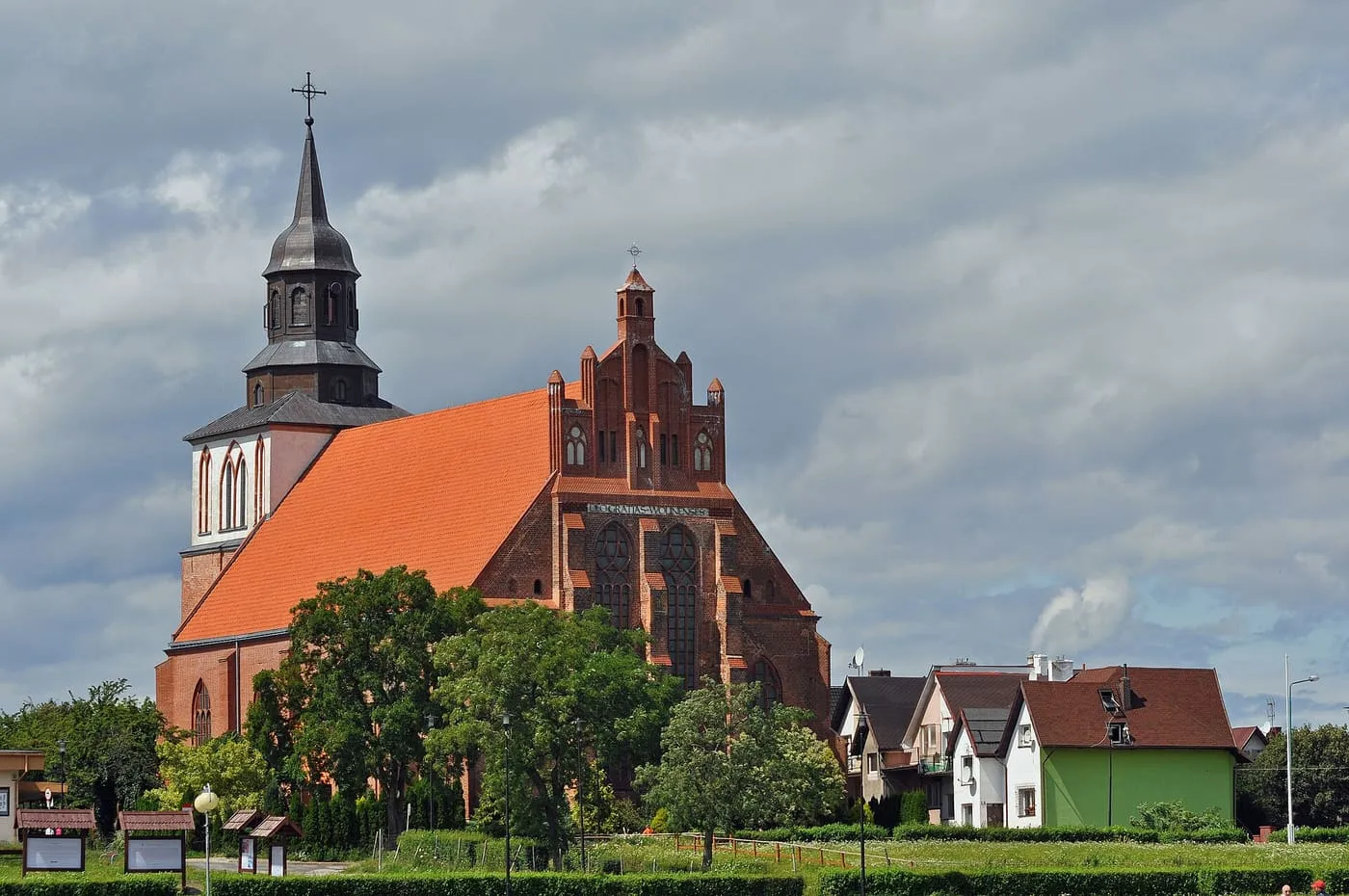 Ceglana, gotycka kolegiata św. Mikołaja w Wolinie ze schodkowym szczytem i napisem „Deo gratias Wolinenses”, pod pochmurnym niebem