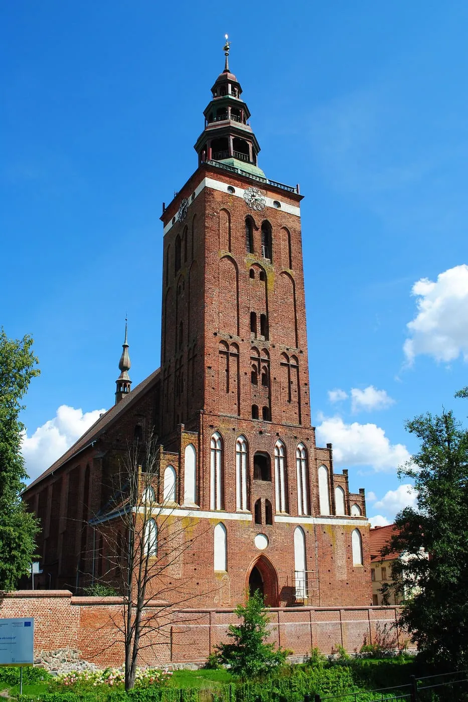 Gotycka, ceglana kolegiata w Lidzbarku Warmińskim z potężną wieżą zwieńczoną barokową latarnią