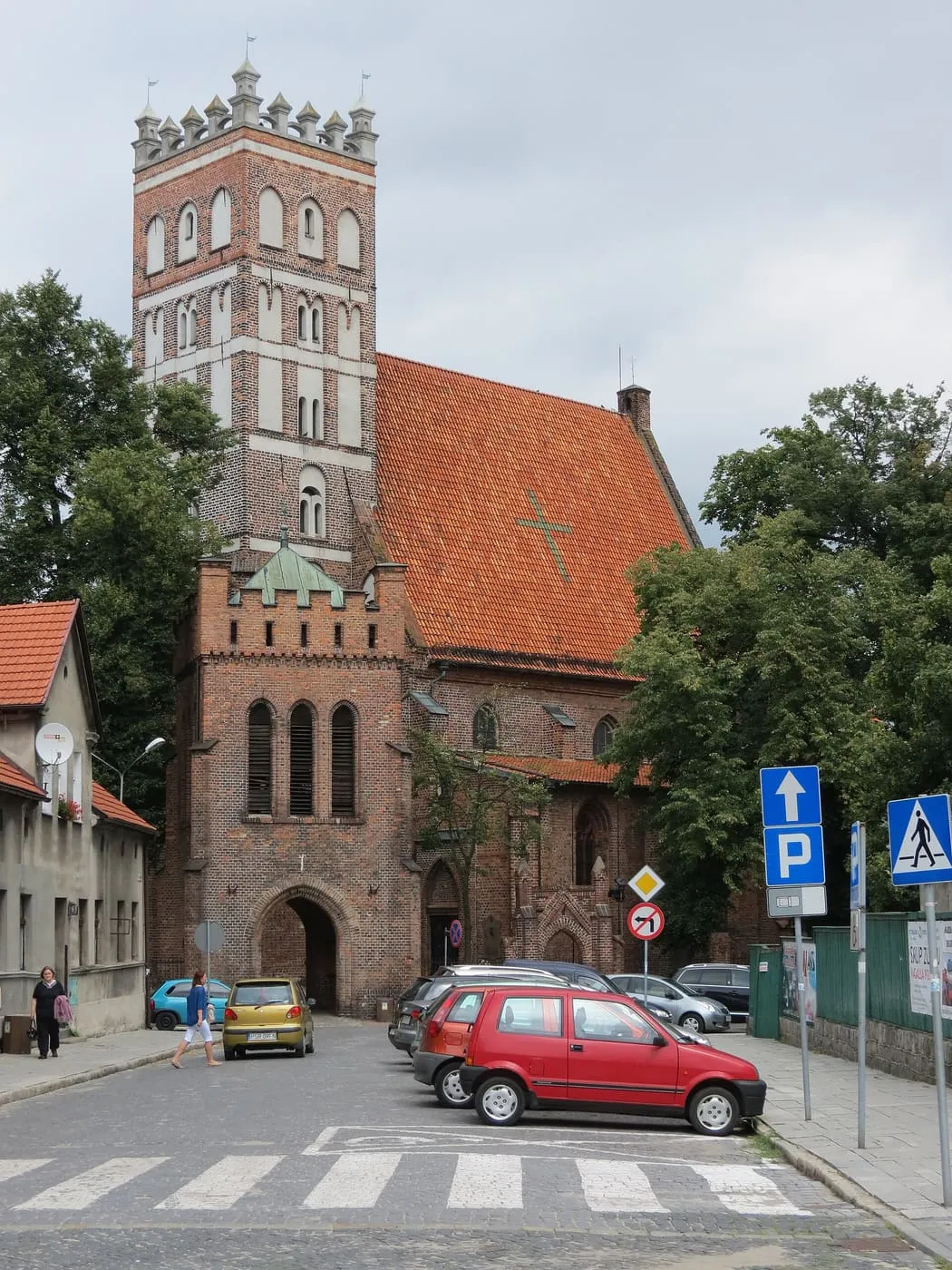 Gotycka, ceglana kolegiata w Środzie Wielkopolskiej z wysoką wieżą o renesansowej attyce ze sterczynami i niższą wieżą bramną z ostrołukowym przejazdem, przy brukowanej ulicy