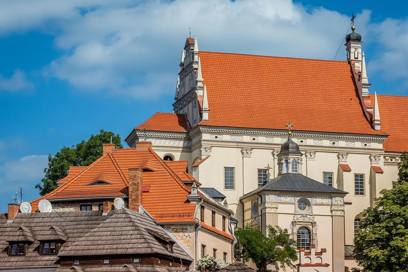 Renesansowe prezbiterium fary w Kazimierzu Dolnym z ozdobnym, schodkowym szczytem, ponad czerwonymi dachami miasteczka