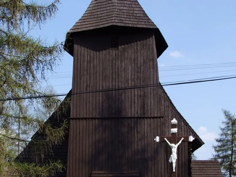 Drewniana wieża starego kościoła w Chocianowicach z krzyżem, kryta gontem