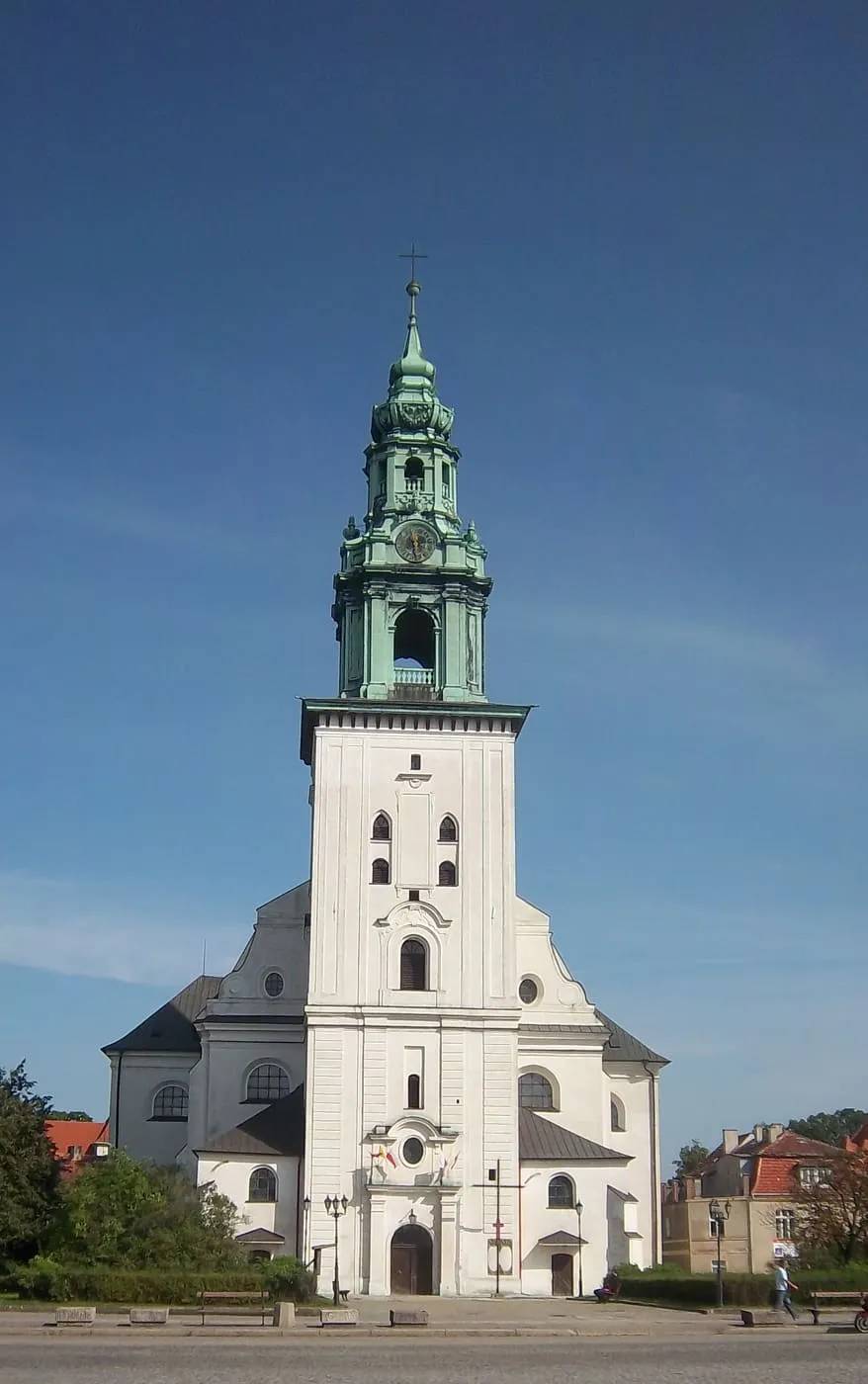 Biała wieża kościoła św. Jadwigi Śląskiej w Krośnie Odrzańskim z barokowym, zielonym hełmem i zegarem