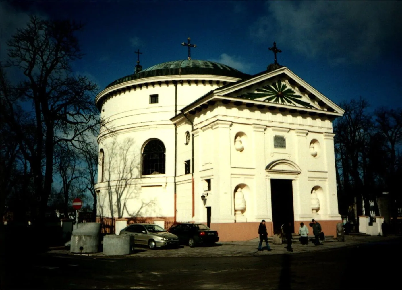 Klasycystyczny kościół św. Jakuba w Skierniewicach na planie koła, z zieloną kopułą, sfotografowany o zmierzchu