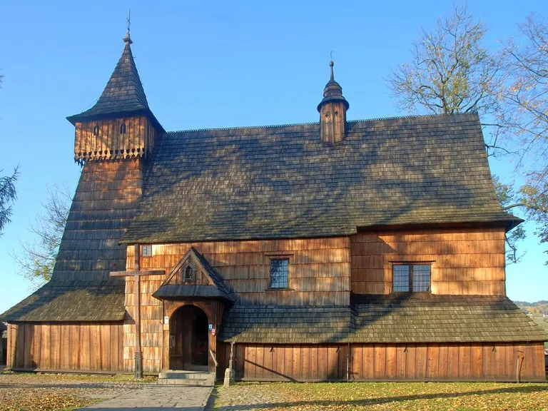 Drewniany kościół św. Michała Archanioła w Dębnie ze smukłą wieżą-dzwonnicą, jesienią