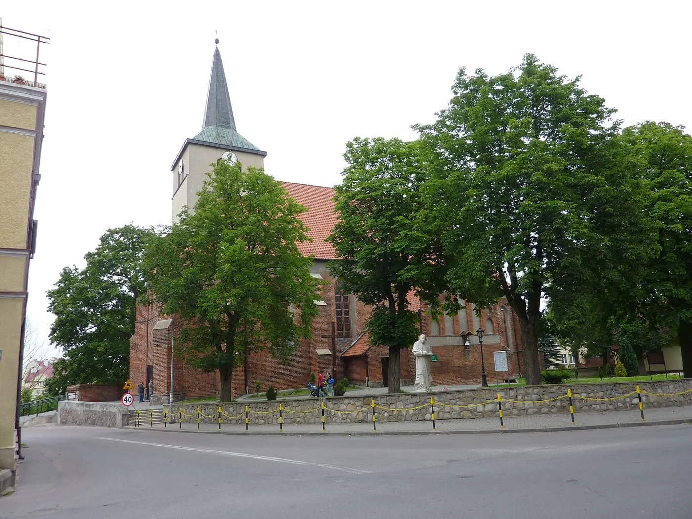 Ceglany kościół św. Michała Archanioła w Skarszewach z wieżą zwieńczoną niewielką kopułką, pod pochmurnym niebem