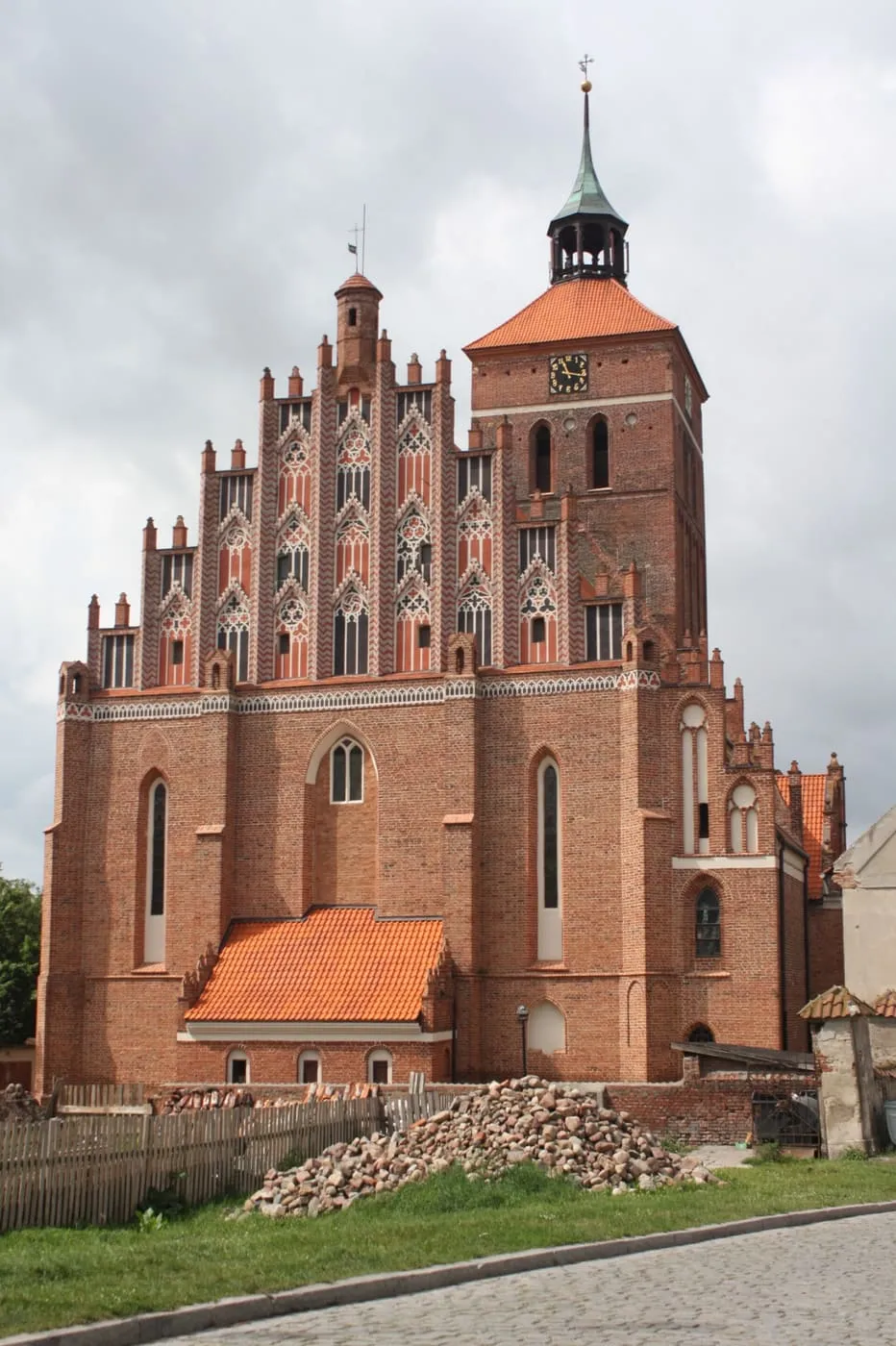 Biały, otynkowany kościół w Reszlu z dwiema wieżyczkami narożnymi, krzyżem na szczycie i napisem „Bazylika” na fasadzie