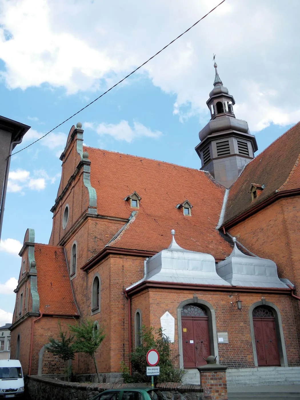 Ceglany, neobarokowy kościół Świętej Trójcy w Kościerzynie z wysoką wieżą, w świetle zachodzącego słońca