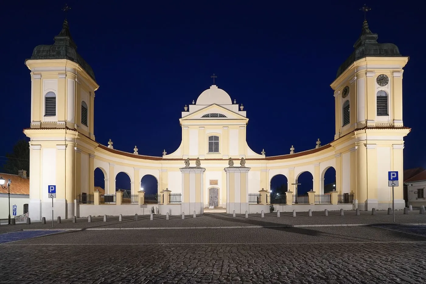 Barokowy kościół w Tykocinie z dwiema wieżami i łukowatą kolumnadą, widok nocny