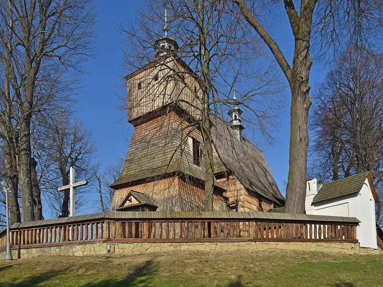 Drewniany kościół Wszystkich Świętych w Bliznem z otaczającymi go sobotami i wielopoziomową wieżą