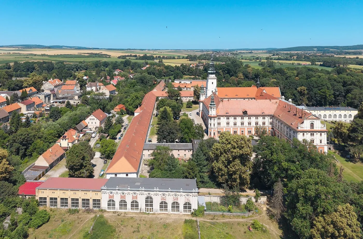 Widok z lotu ptaka na rozległy, barokowy zespół opactwa cystersów w Henrykowie z wieżą kościoła pośrodku