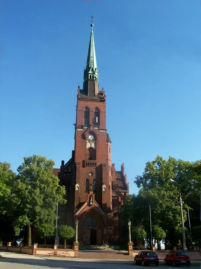 Neogotycki, ceglany kościół Matki Boskiej Nieustającej Pomocy w Opolu z wysoką wieżą zwieńczoną zielonym hełmem