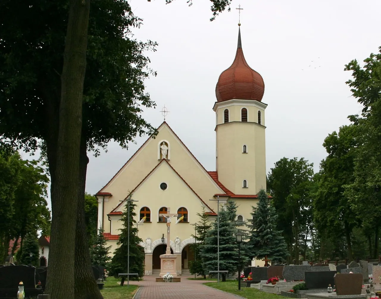 Kremowy kościół Najświętszego Serca Pana Jezusa w Kątach Opolskich z wieżą zwieńczoną czerwonym, cebulastym hełmem