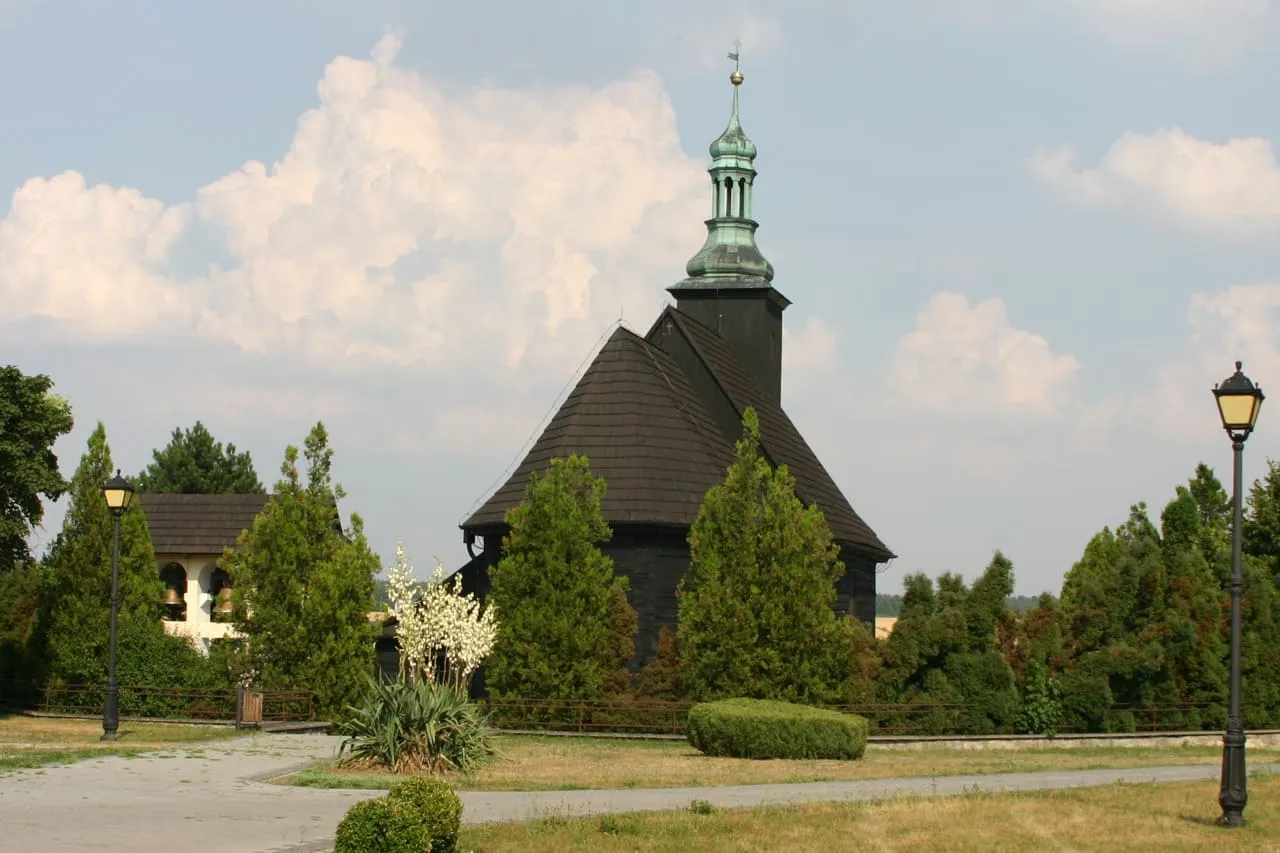 Drewniana, kryta gontem kaplica św. Franciszka ustawiona na dachu murowanego kościoła w Malni, z cebulastą wieżyczką