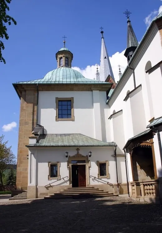 Sanktuarium Matki Bożej Myślenickiej — biała kaplica z zieloną, kopulastą wieżą przy głównej bryle kościoła