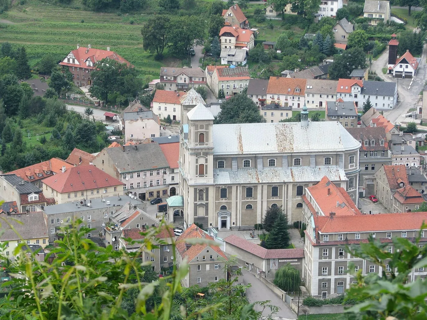 Bardo Śląskie z lotu ptaka — bazylika z jasnym dachem pośród kolorowych dachów miasteczka