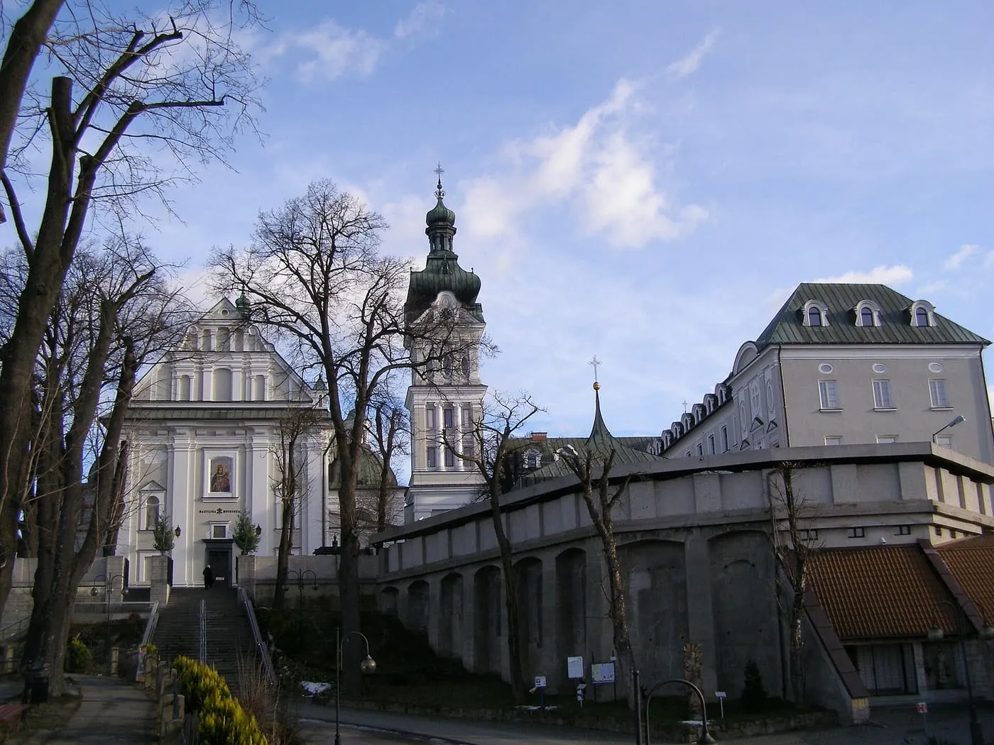 Sanktuarium Matki Bożej Tuchowskiej — dwie białe, barokowe wieże z wizerunkiem Maryi na fasadzie