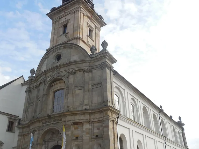 Barokowa fasada bazyliki na Świętym Krzyżu z wielopiętrową wieżą i napisem „Basilica Minor” nad wejściem